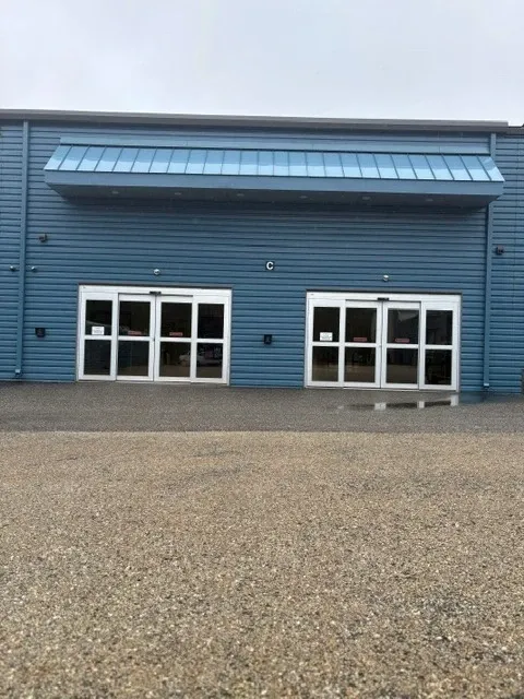 Blue building exterior with two sets of glass doors